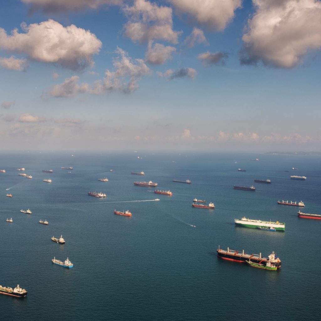 Singapore: Transportation and Container ships wait on the ocean in front of the port of Singapore.