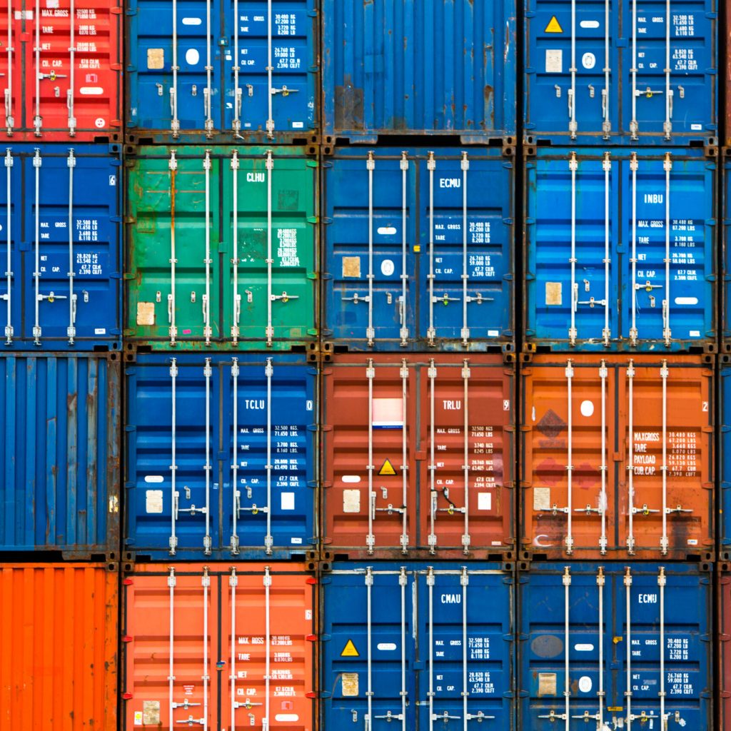 Four vertical rows of shipping containers that are different colors in the Port of Zeebrugge, Belgium